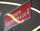 Werbeagentur · Detailaufnahme eines roten Schilds mit weißer Schrift.