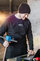 Person mit schwarzer Mütze und schwarzem Pullover mit UTV Logo darauf, hält eine Messsonde in der einer Hand und bedient mit der anderen Hand einen Laptop